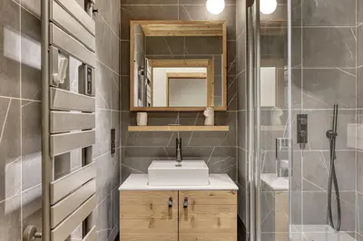 a bathroom with a sink and a mirror at Charmant Appartement au Cœur de Megève avec Jardin privatif in Megève