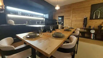a dining room with a wooden table and chairs at Charmant Appartement au Cœur de Megève avec Jardin privatif in Megève