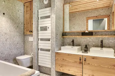 a bathroom with two sinks and a toilet at Charmant Appartement au Cœur de Megève avec Jardin privatif in Megève