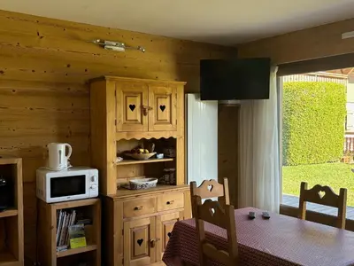 a dining room with a table and a microwave at Marmotton in Megève