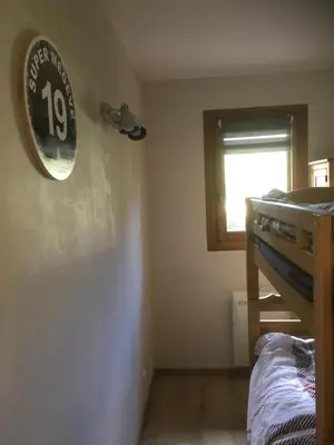 a bedroom with a bunk bed and a clock on the wall at Marmotton in Megève