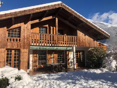 a log cabin with a table in the snow at Chalet Cleo - charmant chalet 180 m2 avec vue montagne in Samoëns