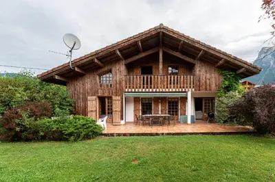 a log house with a deck and a patio at Chalet Cleo - charmant chalet 180 m2 avec vue montagne in Samoëns