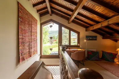 a living room with a large window and a table at Chalet Cleo - charmant chalet 180 m2 avec vue montagne in Samoëns