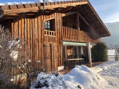 a wooden cabin with a table in the snow at Chalet Cleo - charmant chalet 180 m2 avec vue montagne in Samoëns
