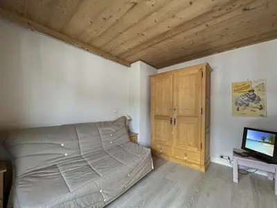 a bedroom with a bed and a wooden cabinet at ARA15 Appartement 6 Pers centre station Carroz in Les Carroz d'Araches