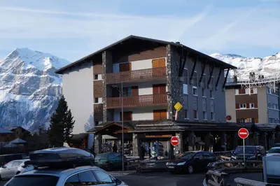 a building on a street in front of a mountain at ARA15 Appartement 6 Pers centre station Carroz in Les Carroz d'Araches