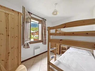a bedroom with a bunk bed and a window at SC316 - Duplex 8 Pers centre des Carroz in Les Carroz d'Araches