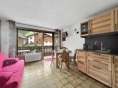 a kitchen with a table and a dining room at CAL02 - Studio 4 Pers centre des Carroz in Les Carroz d'Araches