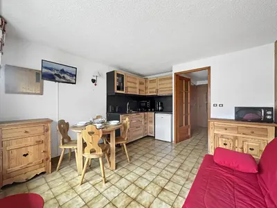 a living room with a table and a kitchen at CAL02 - Studio 4 Pers centre des Carroz in Les Carroz d'Araches