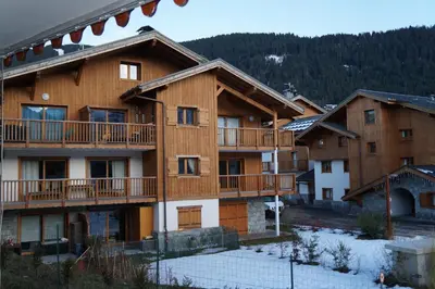a large wooden building with snow on the ground at CAL02 - Studio 4 Pers centre des Carroz in Les Carroz d'Araches