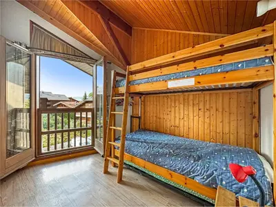 a bedroom with a bunk bed and a balcony at AM104 Duplex 8 Pers centre des Carroz in Les Carroz d'Araches