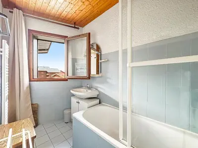 a bathroom with a tub and a sink and a mirror at AM104 Duplex 8 Pers centre des Carroz in Les Carroz d'Araches