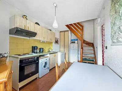 a kitchen with a table and a stove top oven at AM104 Duplex 8 Pers centre des Carroz in Les Carroz d'Araches