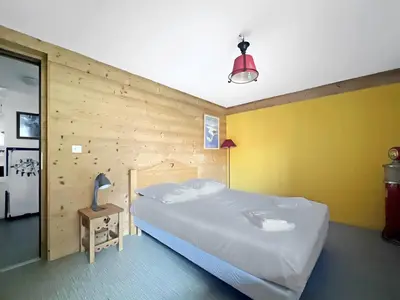 a bedroom with a large bed in a wooden wall at CH719 - Chalet 10 Pers aux Carroz in Les Carroz d'Araches