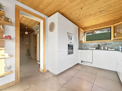 a kitchen with white cabinets and a wooden ceiling at CH719 - Chalet 10 Pers aux Carroz in Les Carroz d'Araches