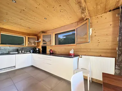a kitchen with white cabinets and a wooden ceiling at CH719 - Chalet 10 Pers aux Carroz in Les Carroz d'Araches