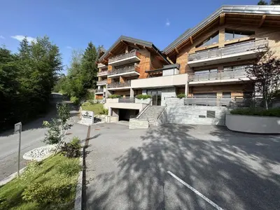 an empty parking lot in front of a building at GCB103 Appartement 10 personnes in Les Carroz d'Araches