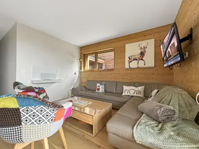 a living room with a couch and a tv at GCB103 Appartement 10 personnes in Les Carroz d'Araches