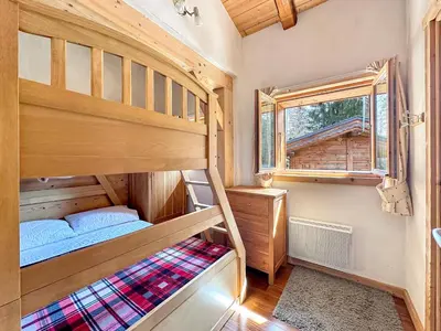 a bedroom with two bunk beds and a window at CH136 - Chalet Kimberley Centre village les Carroz in Les Carroz d'Araches