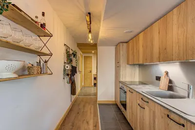 a kitchen with wooden cabinets and a sink at Apartment des Alpages - Alpes Travel - Sleeps 6-8 in Les Trabets