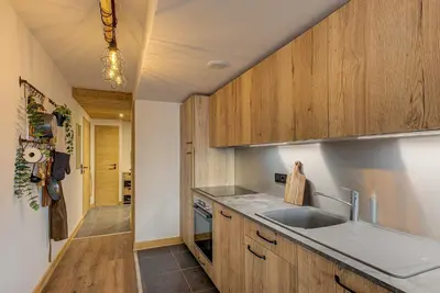 a kitchen with wooden cabinets and a sink at Apartment des Alpages - Alpes Travel - Sleeps 6-8 in Les Trabets