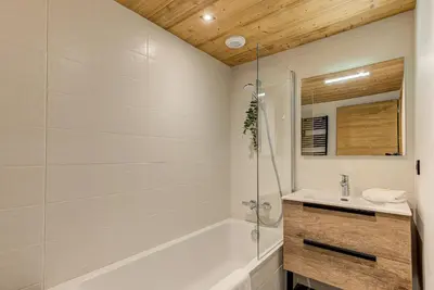 a white bathroom with a tub and a sink at Apartment des Alpages - Alpes Travel - Sleeps 6-8 in Les Trabets