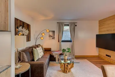 a living room with a couch and a tv at Apartment des Alpages - Alpes Travel - Sleeps 6-8 in Les Trabets