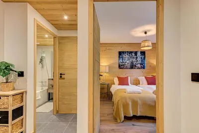 a bedroom with a bed and a bathroom at Apartment des Alpages - Alpes Travel - Sleeps 6-8 in Les Trabets