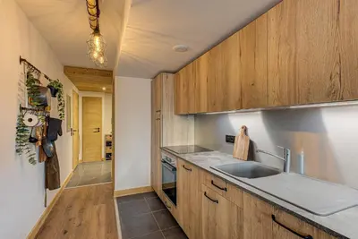 a kitchen with wooden cabinets and a sink at Apartment des Alpages - Alpes Travel - Sleeps 6-8 in Les Trabets