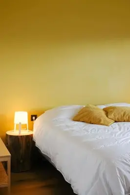 a bedroom with a white bed and a table with a lamp at Maison de montagne in Passy