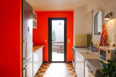 a kitchen with red walls and a red door at Maison de montagne in Passy
