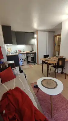 a living room with a wooden table and a couch at Petit cocon proche Saint Gervais in Saint-Gervais-les-Bains