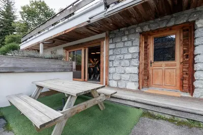 a wooden picnic table sitting outside of a building at Le Covagnet in Saint-Gervais-les-Bains