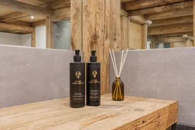 two bottles of shampoo sitting on a wooden table at Le Covagnet in Saint-Gervais-les-Bains
