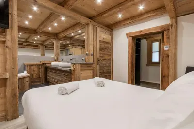 a bedroom with a white bed in a room with wooden walls at Le Covagnet in Saint-Gervais-les-Bains
