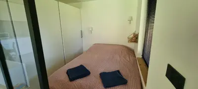 a small room with a bed with two blue pillows at Cabane dans la vallée de Chamonix in Servoz