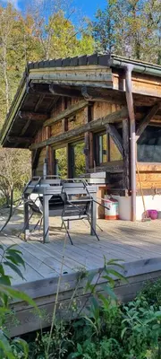 a picnic table and bench on a wooden deck at Cabane dans la vallée de Chamonix in Servoz