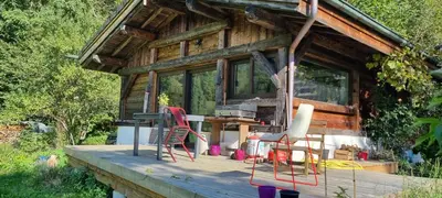 a cabin with chairs and a table on a deck at Cabane dans la vallée de Chamonix in Servoz