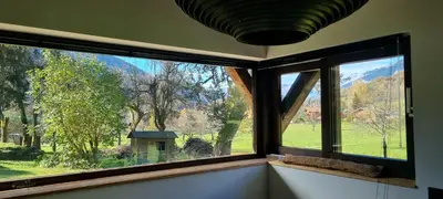 a window in a room with a view of a field at Cabane dans la vallée de Chamonix in Servoz