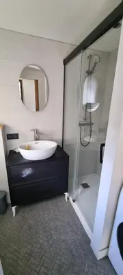 a bathroom with a sink and a shower with a mirror at Cabane dans la vallée de Chamonix in Servoz