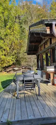 a picnic table and chairs on a wooden deck at Cabane dans la vallée de Chamonix in Servoz