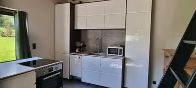 a kitchen with white cabinets and a microwave at Cabane dans la vallée de Chamonix in Servoz