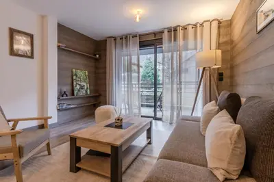 a living room with a couch and a table at Cristal Des Alpes - Superb T3 - Vue Mont-Blanc in Les Houches