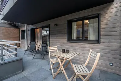 a wooden table and chairs on a patio at Cristal Des Alpes - Superb T3 - Vue Mont-Blanc in Les Houches