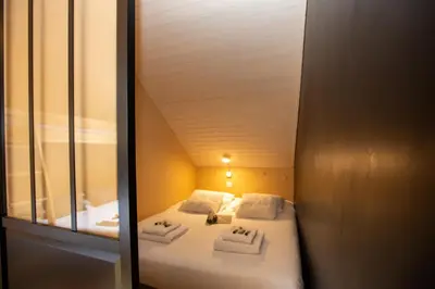 a small room with a bed and a mirror at Les Barrats - Duplex - Central - Vue Mont-Blanc in Chamonix-Mont-Blanc