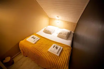 a small bedroom with a bed with towels on it at Les Barrats - Duplex - Central - Vue Mont-Blanc in Chamonix-Mont-Blanc