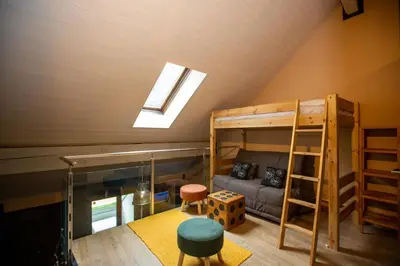 a room with a bunk bed and a couch at Les Barrats - Duplex - Central - Vue Mont-Blanc in Chamonix-Mont-Blanc