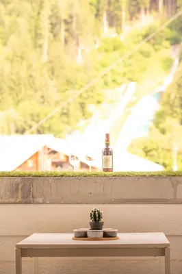 a bottle of wine sitting on a table in front of a window at Les Barrats - Duplex - Central - Vue Mont-Blanc in Chamonix-Mont-Blanc