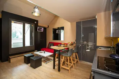 a kitchen and living room with a table and a dining room at Les Barrats - Duplex - Central - Vue Mont-Blanc in Chamonix-Mont-Blanc
